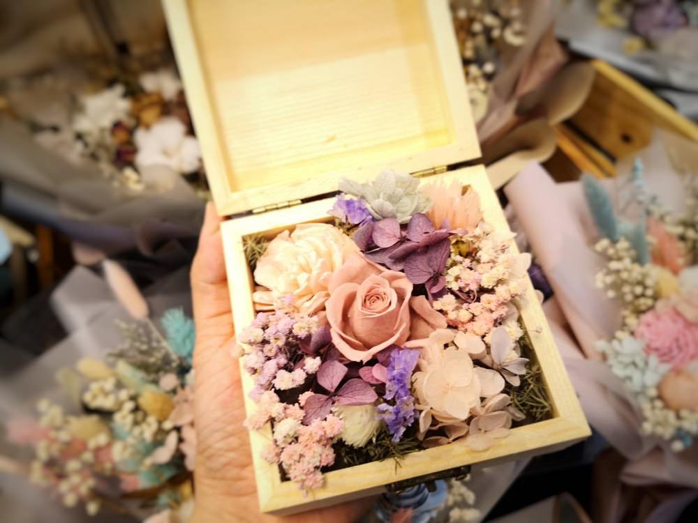 小至10公分以內小木盒，韓式精緻花束、精品永生桌花，大至140公分熊抱花束，「嚐花閣」採用日本進口的永生玫瑰、繡球、索拉花等花材